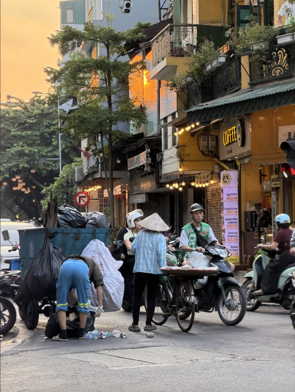 Hanoi'de bir sokakta seyyar satıcılar ve motosikletler